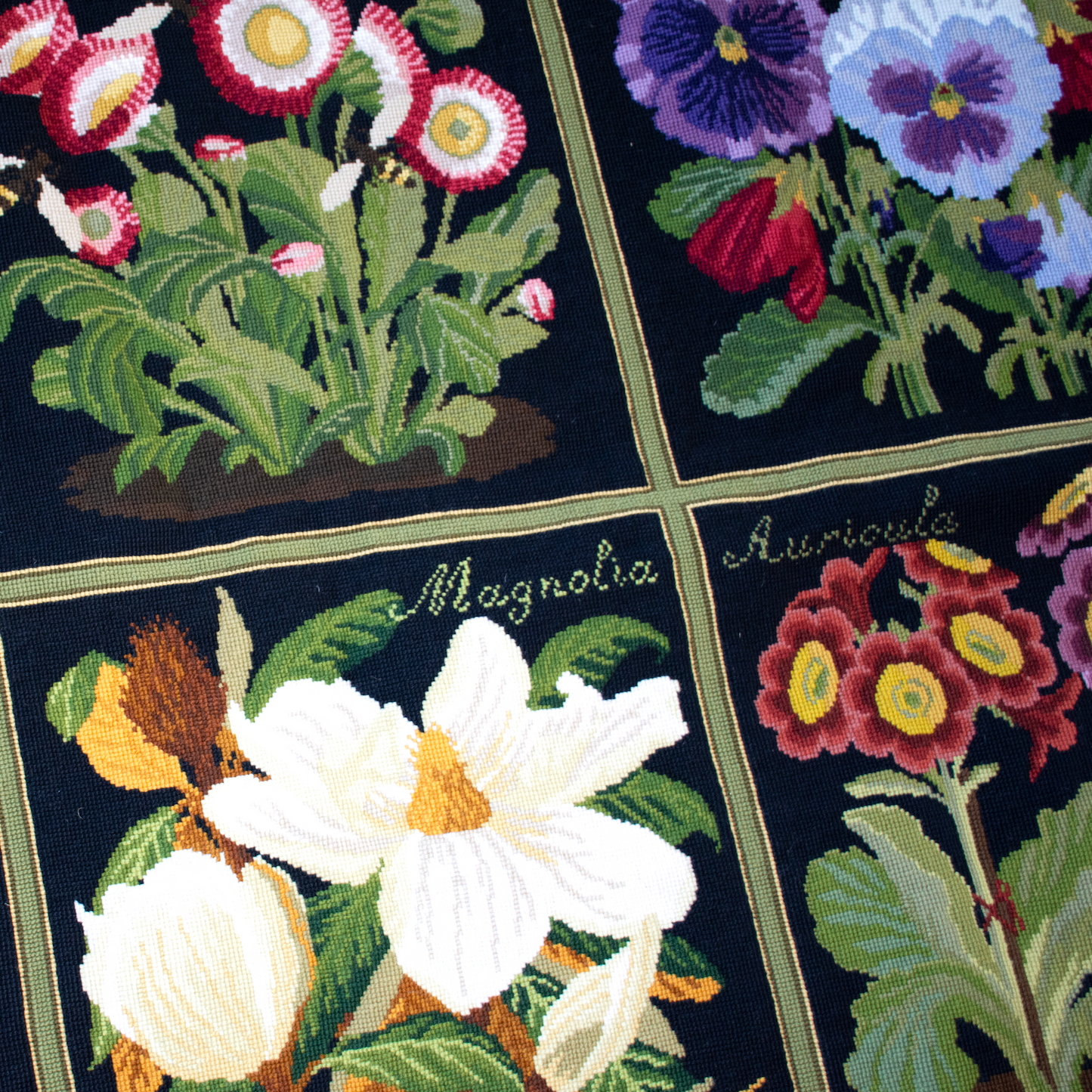 Needlepoint carpet featuring floral designs on a black background