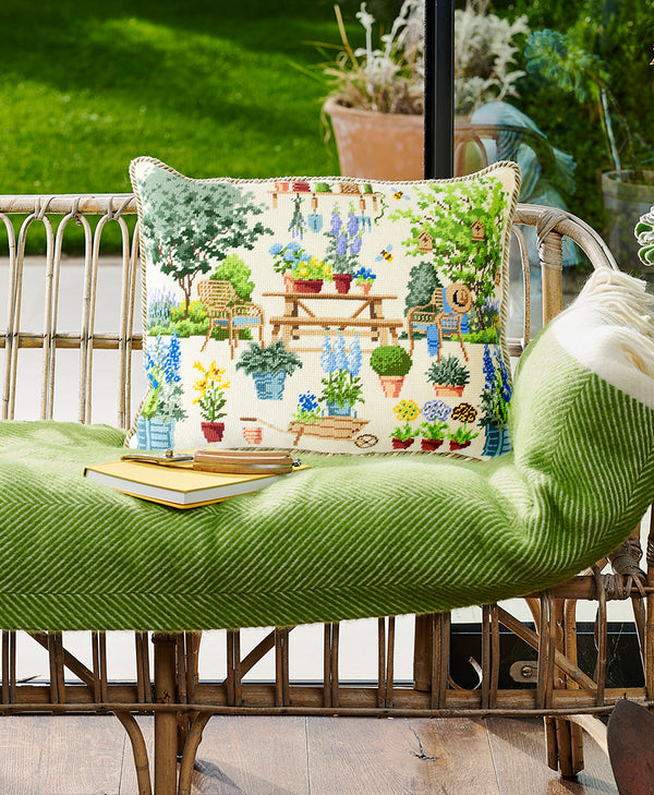 Chelsea courtyard garden finished pillow on rattan couch with green throw blanket